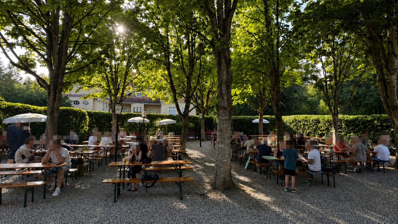 Gut besuchter Biergarten des Jägerhauses unter alten Kastanien; alle Gesichter sind anonymisiert